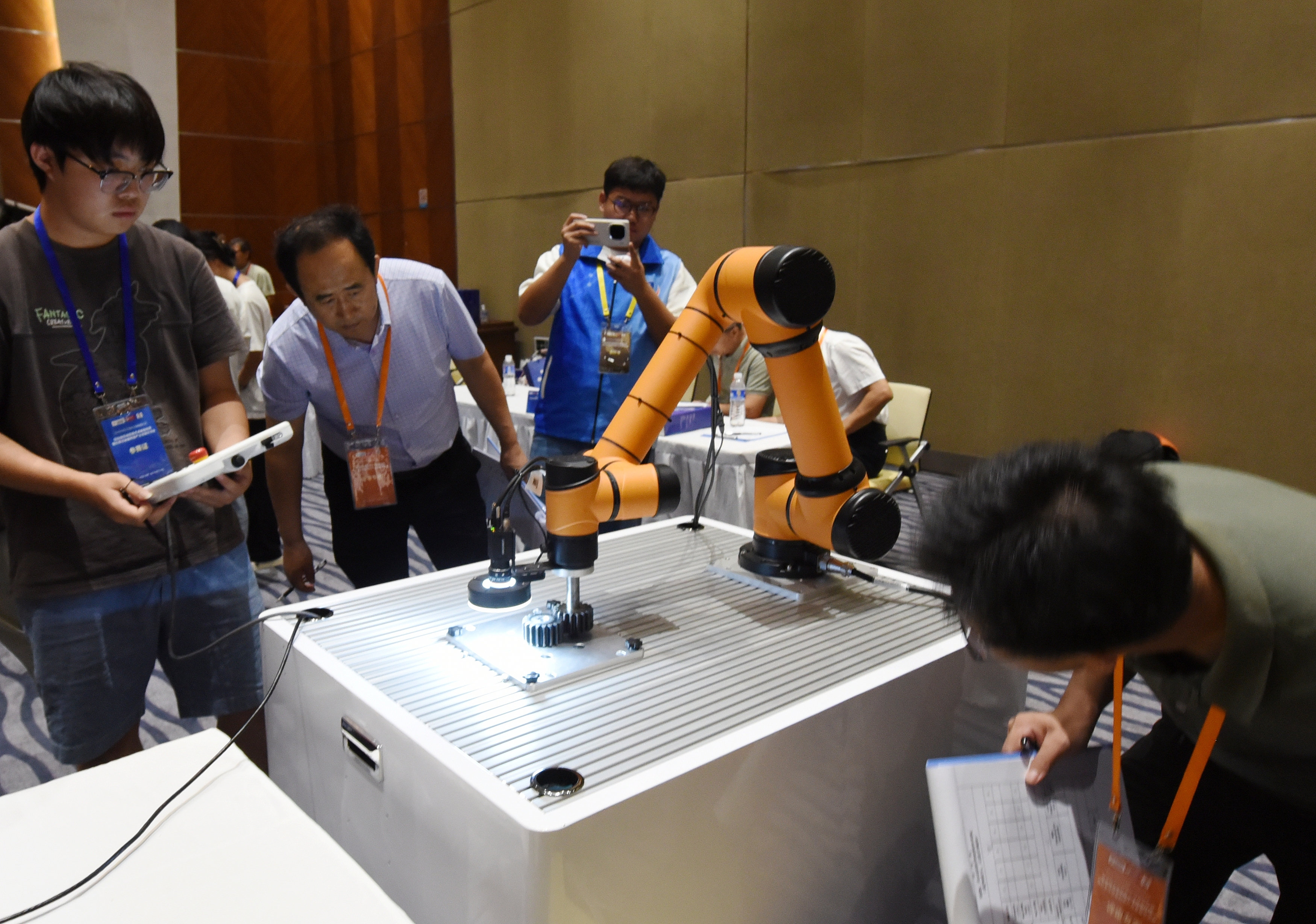 2025年中国大学生机械工程创新创意大赛智能精密装配赛京津冀鲁联赛现场，评委对参赛选手进行实操调试评比。