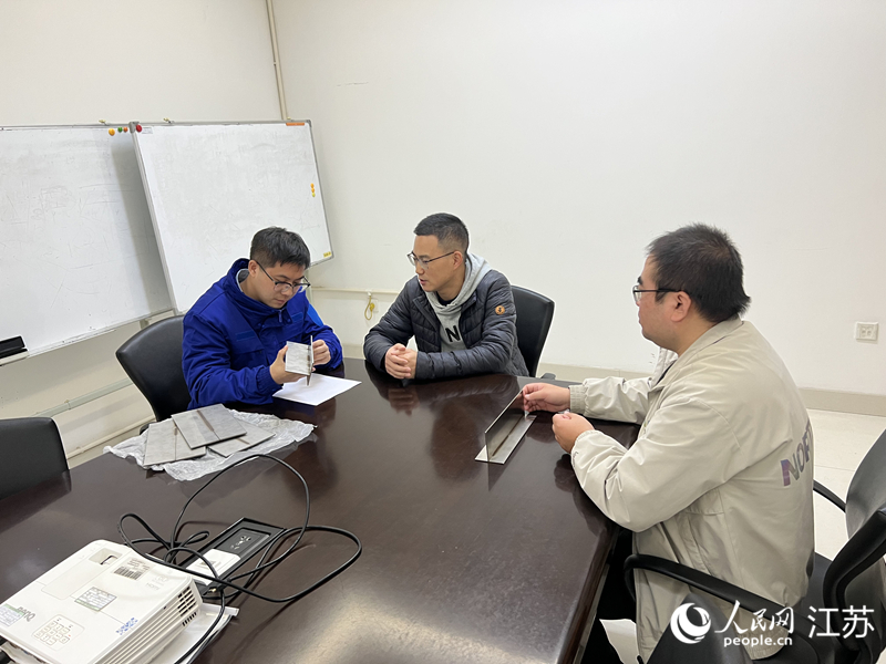 张涛（中）和企业沟通技术细节。人民网 江楠摄