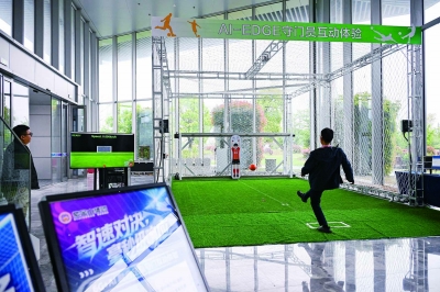 图为AI-EDGE守门员互动体验区，市民与反应速度飞快的机器人“守门员”一起踢足球。 南京日报/紫金山新闻记者 孙中元 摄