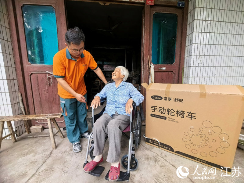 赵颖东正在指导左钟英使用轮椅。人民网记者 王继亮摄