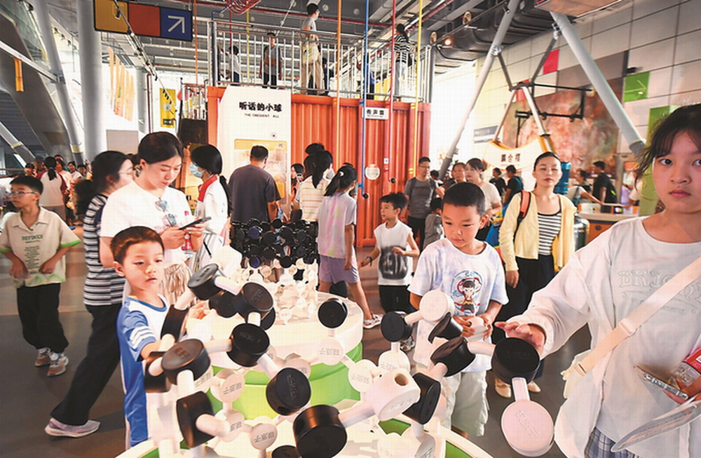 小朋友在家长陪同下在南京科技馆体验科普装置、学习科学知识。杨素平 摄