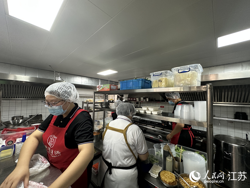 “阿程米线”南通学士府店,后厨在忙碌。人民网 赵登岩摄